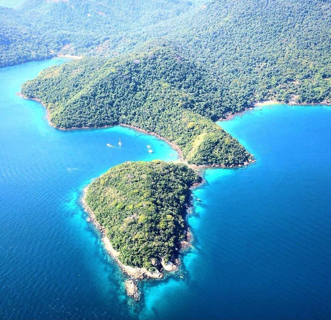 Vista aérea de penínsulas cobertas por mata, enseadas e águas azul-turquesa em Ilha Grande